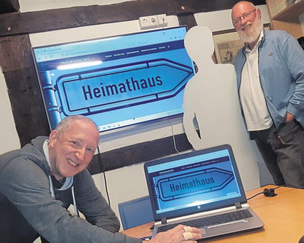 Die modernisierte Webseite des Heimatvereins Verl wird hier von Thomas Dörscheln (Anwendungstechniker, links) und Jochen Melzian (Vorstand) präsentiert. Foto: Heimatverein